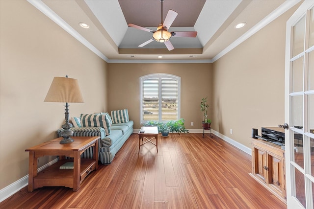 sitting room featuring light wood finished floors, recessed lighting, a raised ceiling, and baseboards