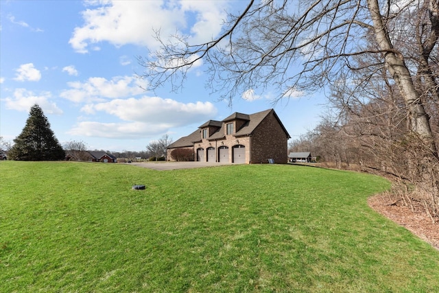 view of yard with a garage and driveway