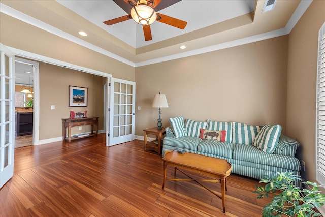 living area featuring wood finished floors, french doors, and a raised ceiling