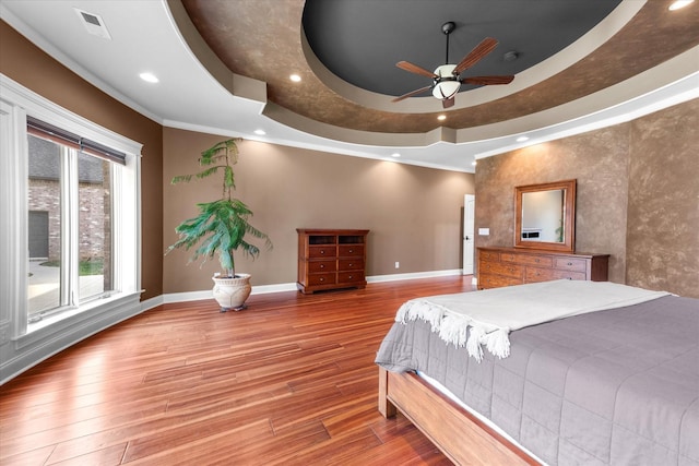 bedroom with recessed lighting, a raised ceiling, baseboards, and wood finished floors