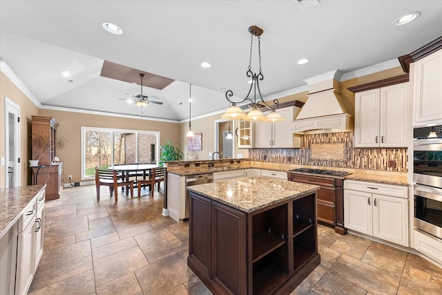 kitchen with lofted ceiling, a peninsula, custom exhaust hood, stainless steel appliances, and backsplash