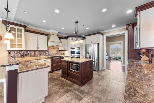 kitchen with light stone countertops, custom exhaust hood, stainless steel appliances, and a sink