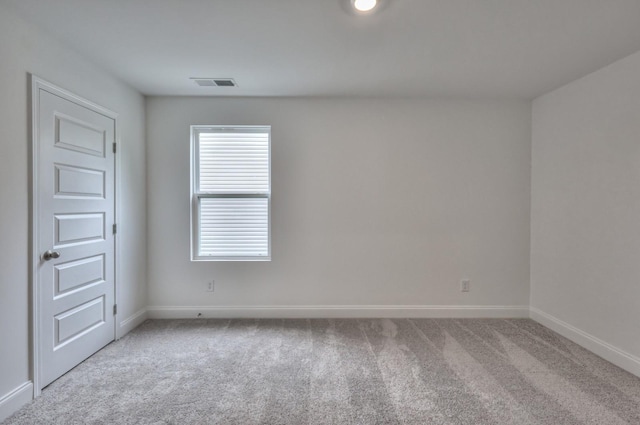 spare room with carpet, visible vents, and baseboards