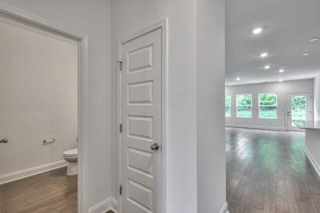 bathroom with recessed lighting, wood-type flooring, toilet, and baseboards