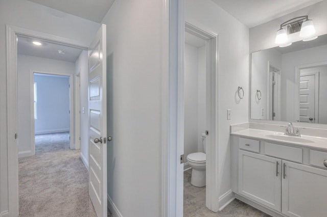 bathroom with vanity, toilet, and baseboards