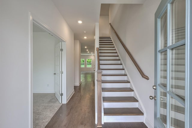 staircase with baseboards, wood finished floors, and recessed lighting