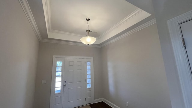 foyer with crown molding, a raised ceiling, baseboards, and dark wood-type flooring