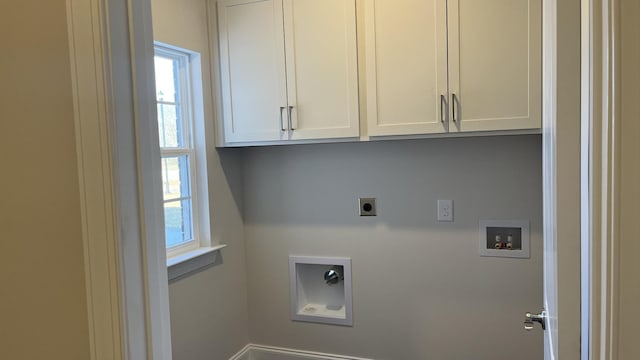 clothes washing area with electric dryer hookup, hookup for a washing machine, plenty of natural light, and cabinet space