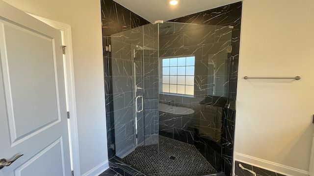 bathroom featuring a marble finish shower and baseboards