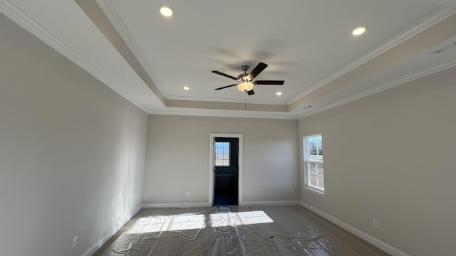 empty room featuring a tray ceiling, a ceiling fan, baseboards, recessed lighting, and ornamental molding