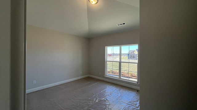 spare room with carpet, lofted ceiling, and baseboards