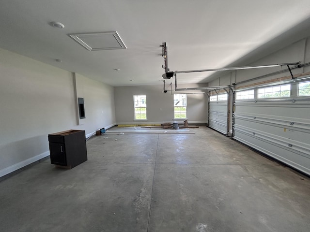 garage featuring a garage door opener and baseboards