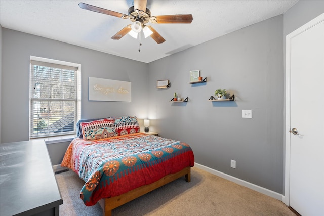 bedroom with carpet floors, ceiling fan, baseboards, and a textured ceiling