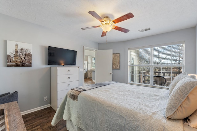 bedroom featuring visible vents, freestanding refrigerator, a textured ceiling, wood finished floors, and baseboards