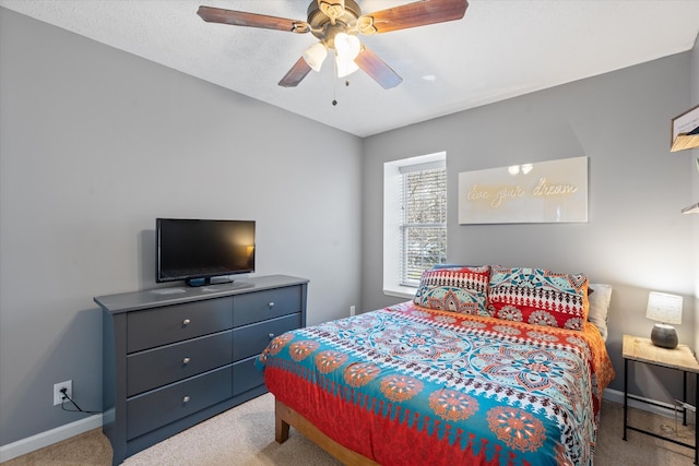 carpeted bedroom with ceiling fan and baseboards