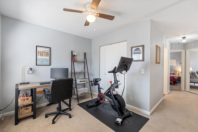 home office with light carpet, ceiling fan, and baseboards