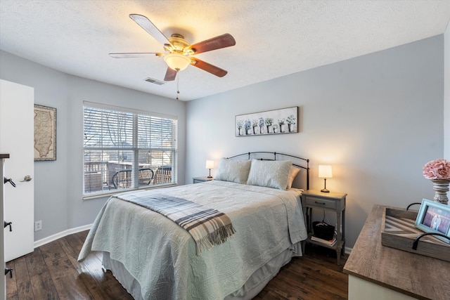 bedroom with dark wood-style floors, a textured ceiling, and visible vents