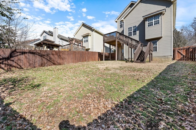 view of yard with fence, a deck, and stairs