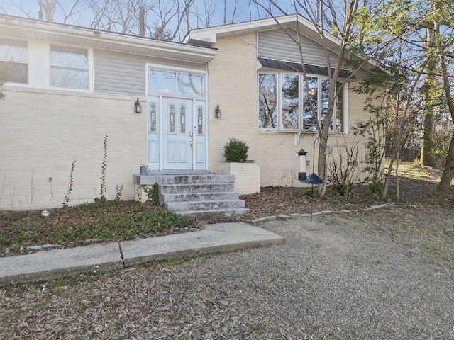 view of exterior entry featuring brick siding