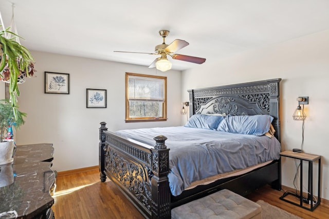 bedroom featuring wood finished floors, a ceiling fan, and baseboards