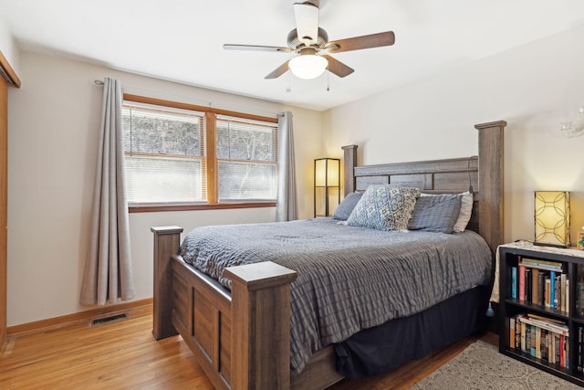 bedroom featuring light wood-type flooring, baseboards, visible vents, and ceiling fan