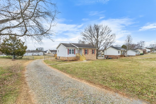 view of front of house featuring fence, driveway, and a front lawn