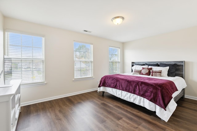 bedroom featuring visible vents, dark wood finished floors, and baseboards