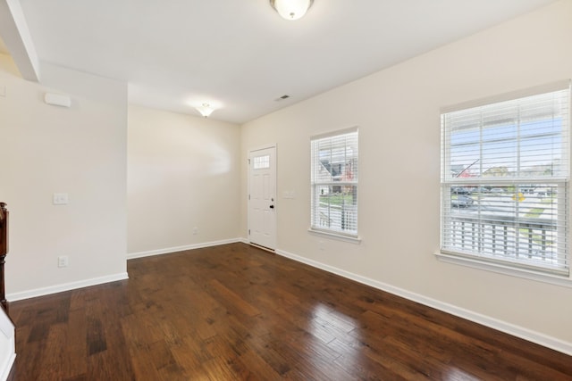 foyer with baseboards, visible vents, and hardwood / wood-style floors