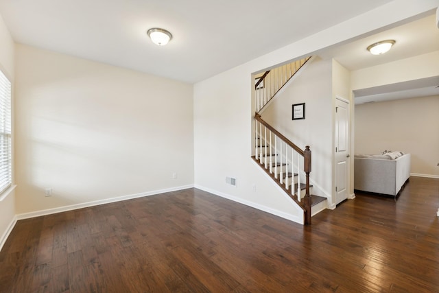 unfurnished room featuring visible vents, stairs, baseboards, and hardwood / wood-style floors