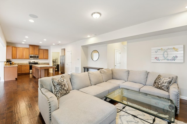 living area with visible vents, dark wood-style flooring, and recessed lighting