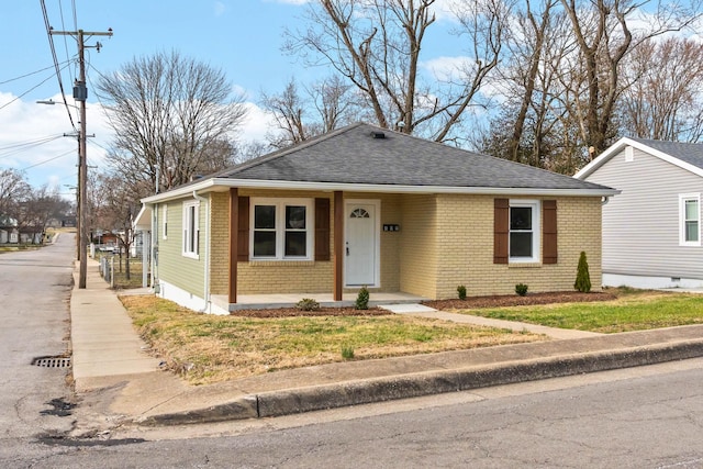 view of front of house with a shingled roof and brick siding