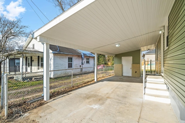 view of patio featuring a fenced front yard, driveway, and a carport