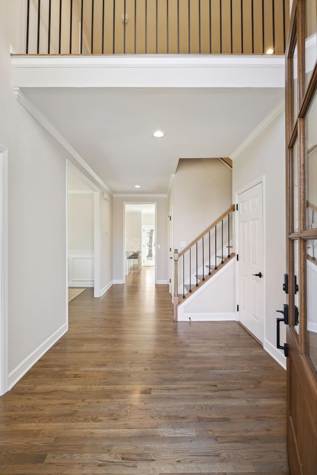 entryway with baseboards, ornamental molding, wood finished floors, stairs, and recessed lighting