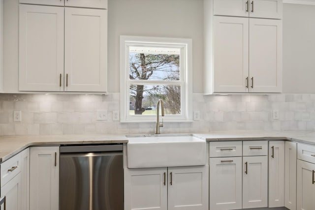 kitchen with a sink, white cabinets, stainless steel dishwasher, decorative backsplash, and light stone countertops