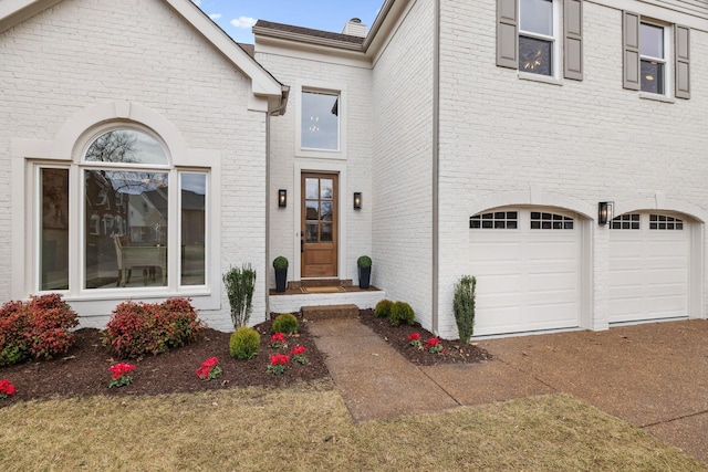 doorway to property featuring brick siding and an attached garage