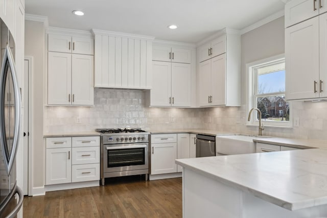 kitchen with appliances with stainless steel finishes, white cabinets, and a sink