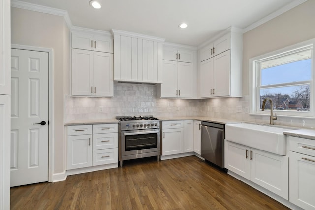 kitchen with appliances with stainless steel finishes, a sink, and white cabinetry