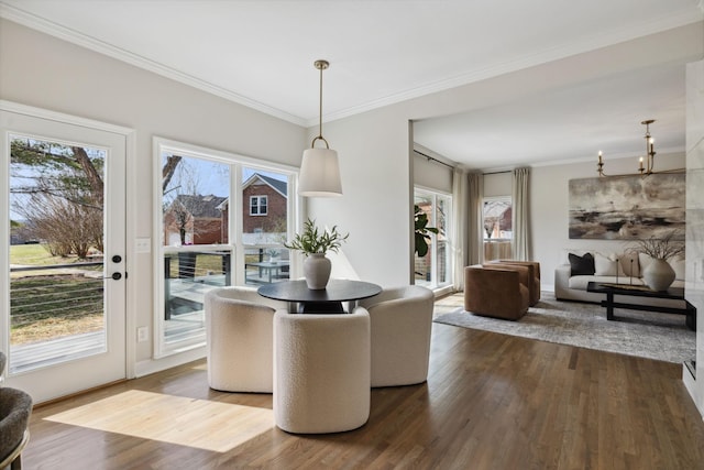 dining room featuring a chandelier, ornamental molding, and dark wood finished floors