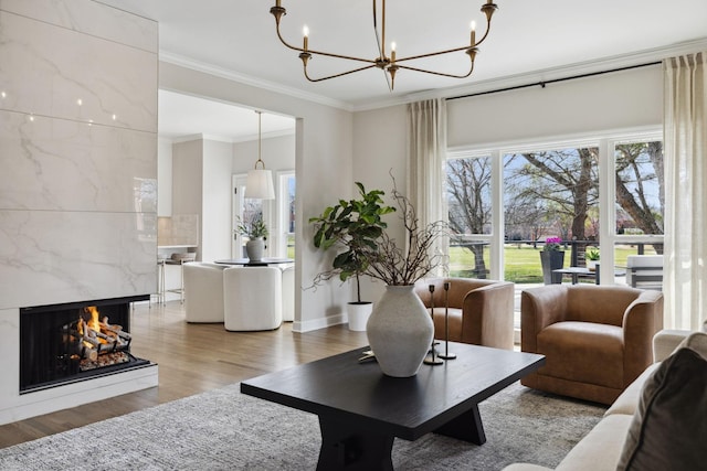 living area with a fireplace, wood finished floors, and crown molding