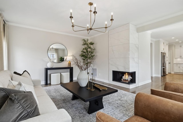 living area with light wood-style floors, a premium fireplace, baseboards, and crown molding