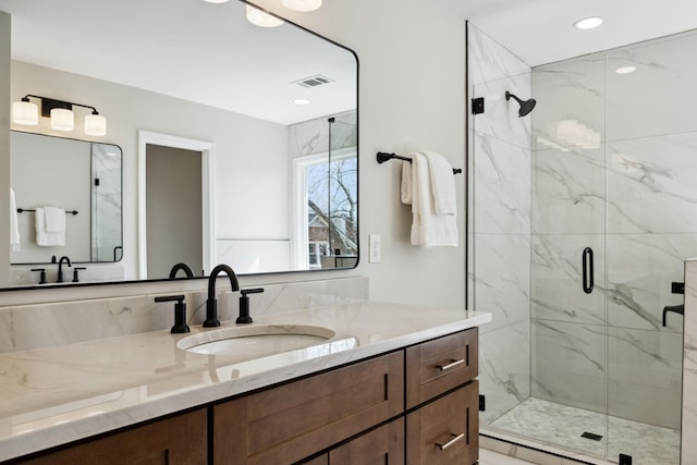 bathroom featuring recessed lighting, visible vents, vanity, and a marble finish shower