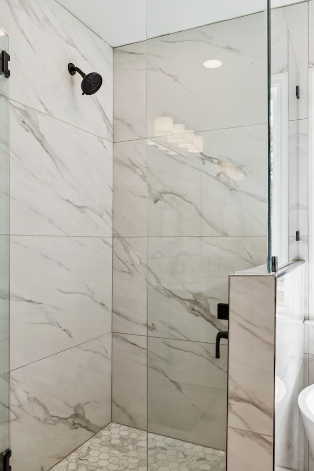 bathroom featuring a marble finish shower