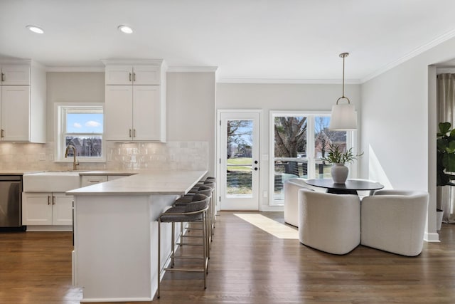 kitchen with dishwasher, dark wood-style flooring, a sink, and white cabinetry