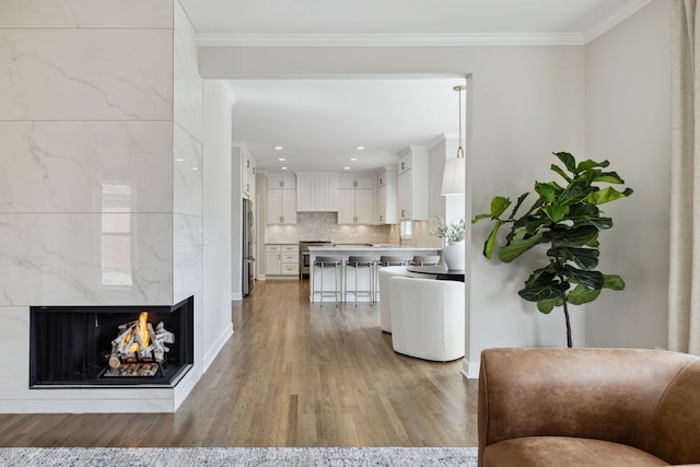 kitchen featuring light wood finished floors, white cabinetry, ornamental molding, and decorative backsplash