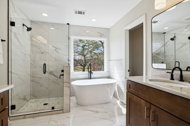 bathroom with visible vents, vanity, a freestanding bath, marble finish floor, and a marble finish shower