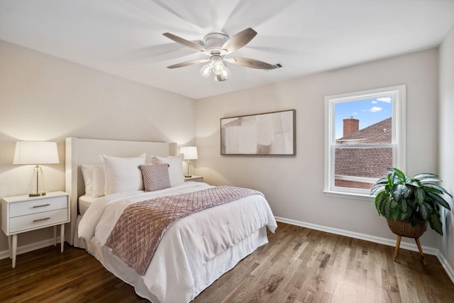 bedroom featuring a ceiling fan, baseboards, and wood finished floors