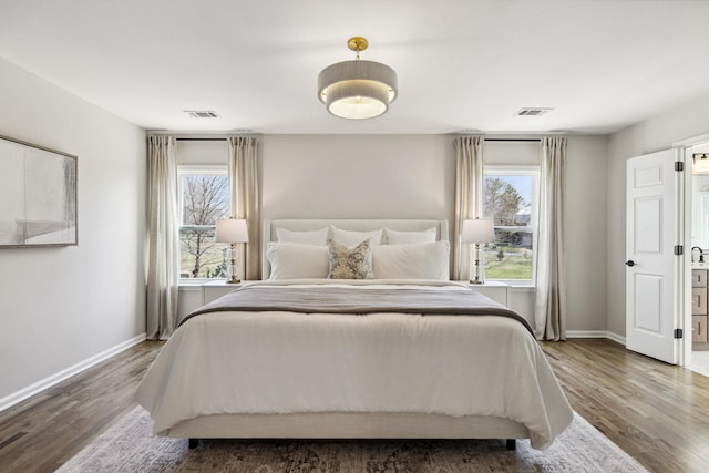 bedroom featuring visible vents, baseboards, and wood finished floors