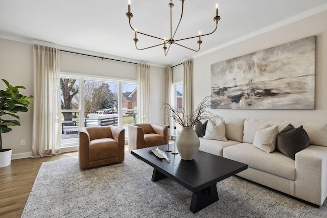 living area featuring baseboards, a notable chandelier, ornamental molding, and wood finished floors