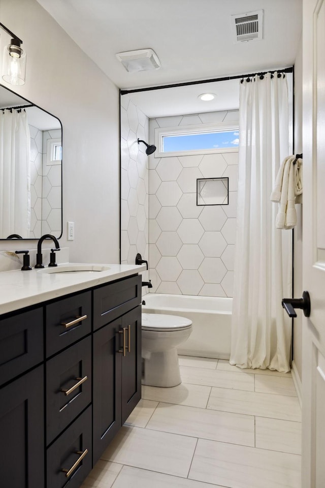 bathroom featuring toilet, vanity, shower / bath combination with curtain, and visible vents