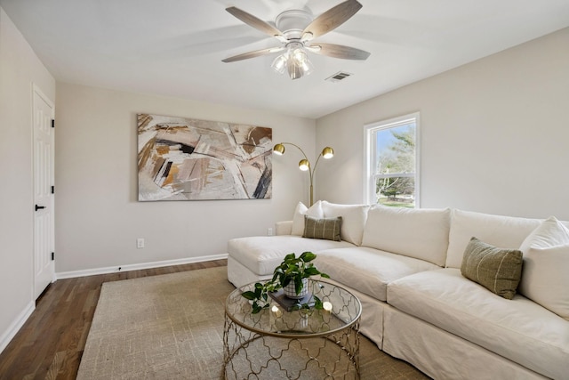 living area with a ceiling fan, baseboards, visible vents, and wood finished floors